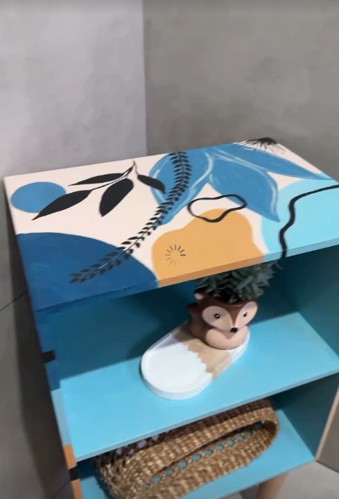 Prateleira azul com pintura de folhas